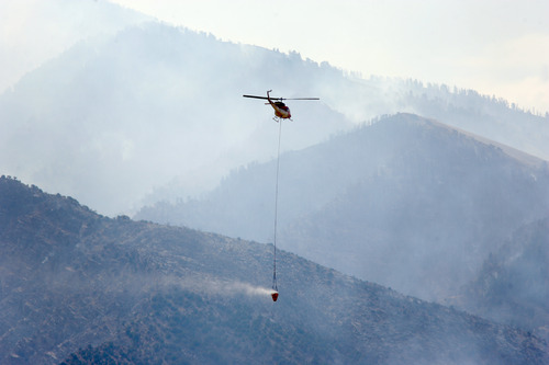 Rick Egan  | The Salt Lake Tribune 

A helicopter carries water to the fire in Skull Valley, Saturday, August 17, 2013.