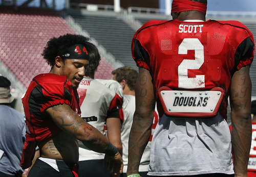 Scott Sommerdorf   |  The Salt Lake Tribune
Utah RB Lucky Radley talks with WR Kenneth Scott about a cut on his arm he got during Utah football practice, Saturday, August 17, 2013.