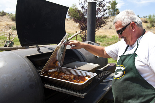 Chris Detrick  |  The Salt Lake Tribune
Dave Alderman checks on the chicken in the smoker during a fundraiser for victims of the Rockport 5 Fire at Rafter B gas station Saturday August 17, 2013. They cooked 100 turkey legs, 100 chicken quarters and about 150 pulled pork sandwiches that were sold to raise money.
