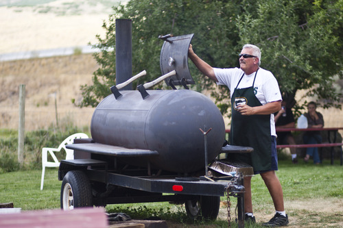 Chris Detrick  |  The Salt Lake Tribune
Dave Alderman cooks meat in his smoker during a fundraiser for victims of the Rockport 5 Fire at Rafter B gas station Saturday August 17, 2013. They cooked 100 turkey legs, 100 chicken quarters and about 150 pulled pork sandwiches that were sold to raise money.