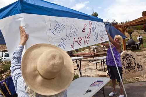 Chris Detrick  |  The Salt Lake Tribune
Sherri Berntsen, left, and Kim Alderman hang up a sign during a fundraiser for victims of the Rockport 5 Fire at Rafter B gas station Saturday August 17, 2013. They cooked 100 turkey legs, 100 chicken quarters and about 150 pulled pork sandwiches that were sold to raise money.
