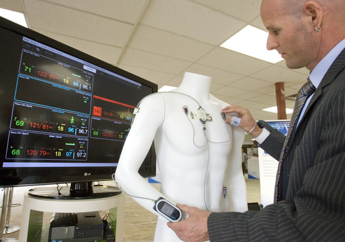 Paul Fraughton  |   The Salt Lake Tribune
Dr. Gunnar Trommer shows off the ViSi Mobile patient monitor on display in the Health Care Transformation Lab. The patient is fitted with sensors and a wrist monitor that shows all vital signs and skin temperature. The information for several patients  is also displayed at a nurses station.    Tuesday, August 20, 2013