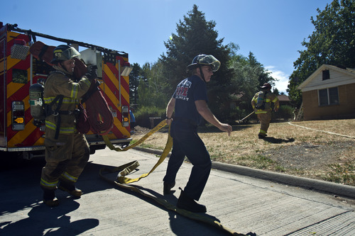 Chris Detrick  |  The Salt Lake Tribune
Salt Lake City firefighters, Matt Hovermale, left, engineer Bruce Emmett, and Capt. Chris Milne take out water hoses during a training drill on an old home, which is scheduled to be demolished, in Salt Lake City Wednesday August 21, 2013.