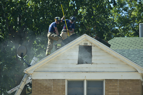 Chris Detrick  |  The Salt Lake Tribune
Salt Lake City firefighters Scott Campau and Greg Holmes check a veneration hole cut in the roof during a training drill on an old home, which is scheduled to be demolished, in Salt Lake City Wednesday August 21, 2013.