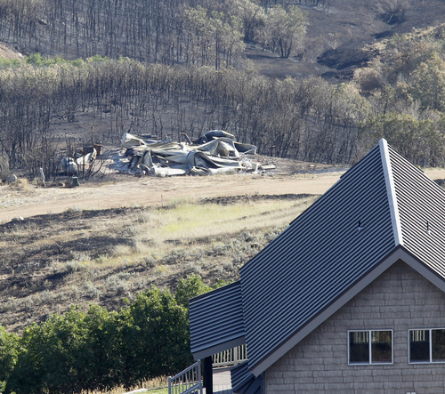 Al Hartmann  |  The Salt Lake Tribune
Rockport Estates home is burned down to its foundation while a house across the road survived the Rockport 5 Fire. Residents were allowed to return to their homes Monday August 19.