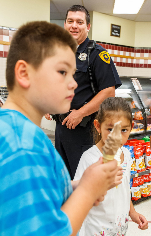 Trent Nelson  |  The Salt Lake Tribune
Detective Brandon Shearer hands out ice cream cones to citizens in a community outreach program in Salt Lake City, Thursday July 25, 2013.