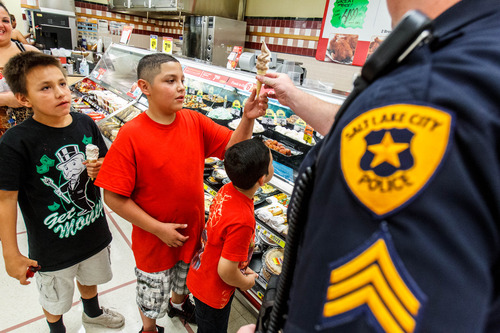 Trent Nelson  |  The Salt Lake Tribune
Detective Brandon Shearer hands out ice cream cones to Ernie Martinez, Esequiel Torres and Manuel Monrreal in a community outreach program in Salt Lake City, Thursday July 25, 2013.
