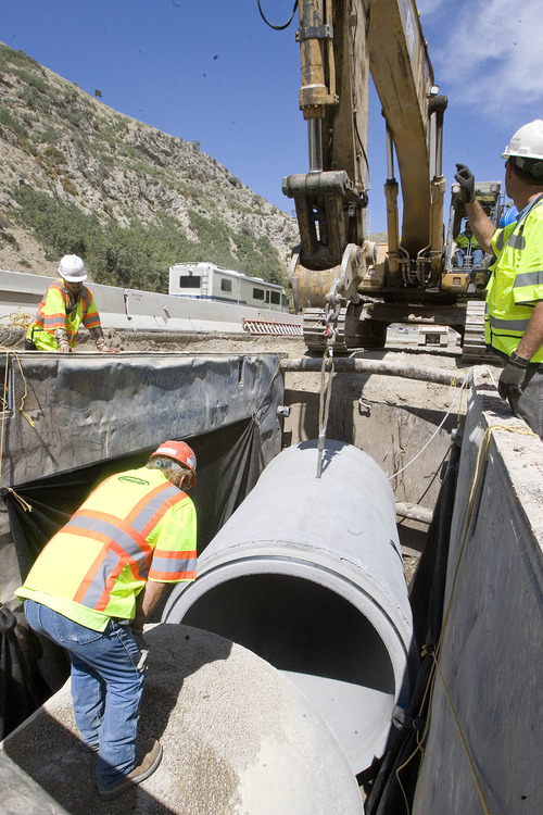 Paul Fraughton  |   The Salt Lake Tribune
Workers install a 12-foot section of concrete pipe into place on the Parley's Canyon culvert project. The workers are averaging around nine sections a day and are halfway finished. When complete, the pipe will stretch for two miles down the canyon.           Wednesday, August 21, 2013
