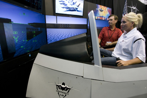 Rick Egan  | The Salt Lake Tribune 

Gary Hentz gives directions to ATK employee Charlene Yocham as she sits in the F-35 Lightning II interactive cockpit demonstrator at ATK on Wednesday, Aug. 20, 2013.  The cockpit demonstrator simulates the fighter aircraft's advanced technologies and combat capabilities.