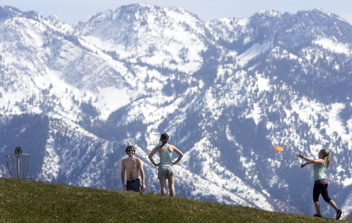Steve Griffin  |  The Salt Lake Tribune
 
The snow covered Wasatch Mountains loom in the background as University of Utah students Tyler Gentry, Lindsey Parsons and Caitlin Janeway enjoy the warm spring weather as they play a round of disc golf on the university  course in Salt Lake City, Utah Friday, April 1, 2011.