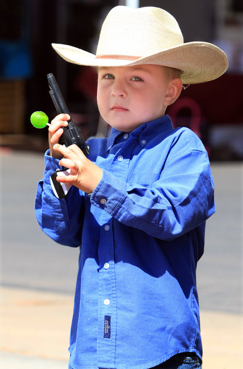 Rick Egan   |  The Salt Lake Tribune

4-year-old Ethan Hampton, Cimmaron New Mexico, holds his sucker and a gun, as he watches the parade, during the Western Legends Round Up Saturday August 28, 2010.