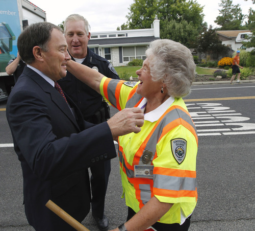 Al Hartmann  |  The Salt Lake Tribune
School crossing guard Leora Farnsworth, 79, gets hugs of thanks and congratulations for her 39 years of service from Gov. Gary Herbert and Salt Lake County Sheriff James Winder on Spring Lane in Holladay on Friday. Herbert declared Friday as Crossing Guard Appreciation Day, recognizing crossing guards' efforts to keep the Utah children safe.