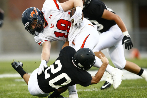 Chris Detrick  |  The Salt Lake Tribune
Mountain Crest's Nick Taylor (19) is tackled by Highland's Thomas Pembroke (20) during the game at Highland High School Thursday August 22, 2013. Highland is winning the game 30-0 at halftime.