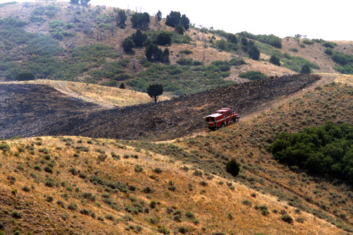 Rick Egan  |  The Salt Lake Tribune 
A firetruck drives along the ridge as a grass fire burns in the Rosecrest area of Herriman, Saturday, August 24, 2013.
