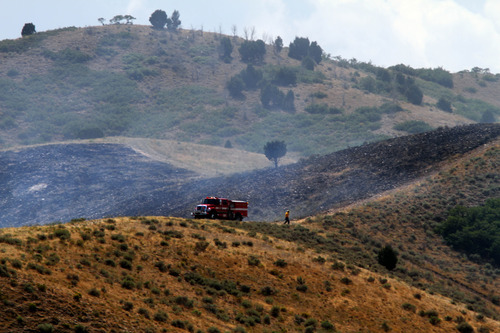 Rick Egan  |  The Salt Lake Tribune
Firefighters walk along the ridge, as a grass fire burns in the Rosecrest area of Herriman, Saturday, August 24, 2013.