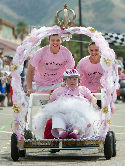 Steve Griffin  |  The Salt Lake Tribune
Michael Hatch and Parker Wilcox are all smiles as they cross the finish line with princess Melinda Gulbranson grabbing first place in the fifth annual Pallet Grand Prix in the Layton Hills Mall parking lot on Friday. "The Moms" entry in the field had a princess theme and went undefeated for the day. The team defeated the Brady Industries entry of Eric Miller, Mark Larsen and Ryan Knight in the final race.