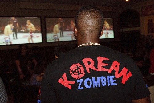 Leah Hogsten | The Salt Lake Tribune
Temell Buggs sports his "Korean Zombie" t-shirt while watching the Korean Zombie vs Josa Aldo match at Lumpy's Downtown bar during Saturday's Ultimate Fighting Championship pay-per-view TV event, August 3, 2013. UFC, the most elite mixed martial arts promoter by far, once planned an event for Salt Lake City and canceled  because of poor early ticket sales. UFC has a particularly strong Utah following, and pay-per-view numbers are said to be off the charts and Utahns are clamoring for a UFC event at EnergySolutions.