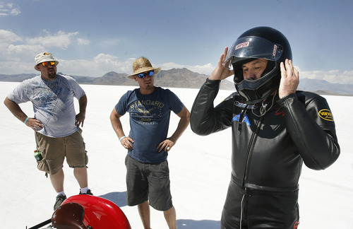Scott Sommerdorf  |  The Salt Lake Tribune
Crew members Ronnie Wilson, left, and Matt Inscho, center, watch as Dan Parker, a race car driver who lost his sight last year in an accident, puts on his helmet prior to a practice runs on the Bonneville Salt Flats, Sunday, August 25, 2013.