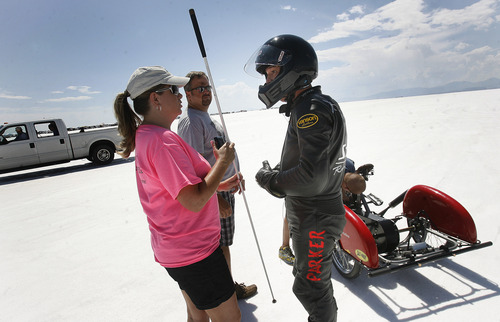 Scott Sommerdorf   |  The Salt Lake Tribune
Jennifer Stegall, left, is about to hand blind race driver Dan Parker a white walking stick in preparation for some publicity photos next to his racing motorcycle, on the Bonneville Salt Flats, Sunday, August 25, 2013. Parker is a race car driver who lost his sight last year in an accident.