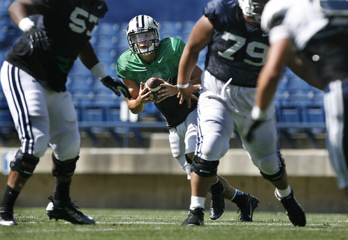 Scott Sommerdorf   |  The Salt Lake Tribune
BYU QB Taysom Hill rolls out behind blocking from his offensive line during football practice at BYU, Wednesday, August 21, 2013.