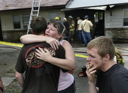 Scott Sommerdorf   |  The Salt Lake Tribune
Stacie Jackson, center, hugs her son T.J. Jackson in the aftermath of a fire at 25 W. 600 North in Tooele, Wednesday, August 28, 2013. Her son's apartment was one of two units most affected by the fire.