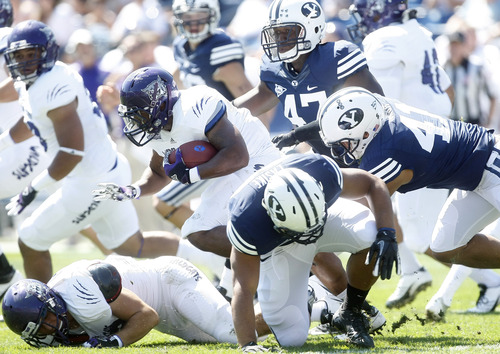 Chris Detrick  |  The Salt Lake Tribune
Weber State Wildcats running back Kris Parham (7) is tackled by BYU's Ezekiel Ansah (47) and  Uani Unga (41) during the first half of the game against Weber State at LaVell Edwards Stadium Saturday, Sept. 8, 2012.