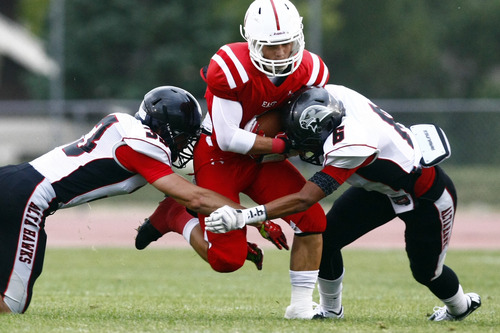Chris Detrick  |  The Salt Lake Tribune
East's Malaki Solovi (1) is tackled by Alta's Quinn Fabrizio (33) and Tejon Reeves (6) during the game at East High School Friday August 23, 2013. East is winning the game 21-10 at halftime.