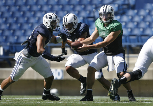 Scott Sommerdorf   |  The Salt Lake Tribune
BYU QB Taysom Hill fakes the handoff to RB Michael Alisa prior to a rollout during football practice at BYU, Wednesday, Aug. 21, 2013.