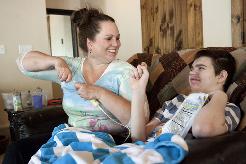 Steve Griffin | The Salt Lake Tribune

Jennifer May feeds her son, Stockton, through a tube as he smiles and watches television at their Pleasant Grove, Utah, home Tuesday Aug. 27, 2013.  Stockton, who has severe seizures, has tried 25 other treatments prescribed by doctors. Jennifer May now wants to try medical marijuana.