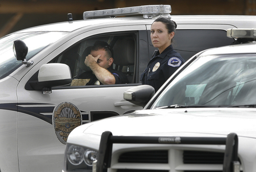 Scott Sommerdorf   |  The Salt Lake Tribune
Two South Jordan police officers pause while talking near a roadblock at the intersection of 12400 South, and Fort Street in Draper, Sunday, September 1, 2013. Draper police Sgt. Derek Johnson was shot and killed just south of there.