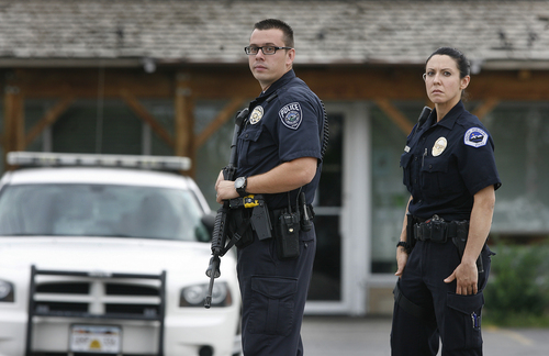 South Jordan police officers stand at a roadblock at the intersection of 12400 South, and Fort Street in Draper, Sunday, Sept. 1, 2013. Draper police Sgt. Derek Johnsonwas shot and killed just south of there. (AP Photo/The Salt Lake Tribune, Scott Sommerdorf)