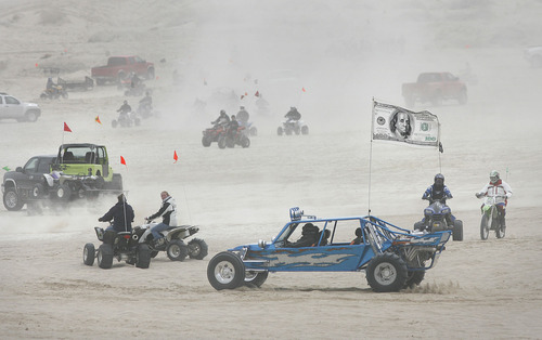 Scott Sommerdorf  |  Salt Lake Tribune
LITTLE SAHARA
A "sand rail" dune buggy with a $100 bill flag drives among other off-road enthusiasts at Little Sahara National Recreation Area, Saturday 4/3/10. Some of the people that come to Little Sahara each year spend thousands of dollars on their hobby. Four- and two-wheel enthusiasts, dune buggies and more kick off the spring season with motorized recreation and camping at Little Sahara sand dunes., Saturday 4/3/10.