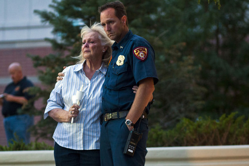 Launi Smith and her son Unified Fire Authority battalion chief Clint Smith listen during a candlelight vigil for Sgt. Derek Johnson at Draper City Hall Sunday Sept. 1, 2013. "This is a very tragic day for the Draper city police department," said Draper Police Chief Bryan Roberts.  (AP Photo/The Salt Lake Tribune, Chris Detrick)