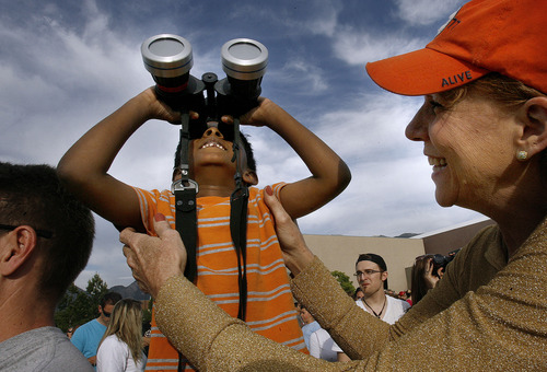 Scott Sommerdorf  |  The Salt Lake Tribune             
Susan Jarvis helps six year old Vishwa Murudappan see the first part of the annular eclipse from Dimple Dell Recreation Center, Sunday, May 20, 2012.  Cloud cover later obscured the maximum stage and kept the crowd of about three hundred from seeing the "ring of fire".