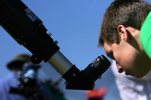 Kim Raff | The Salt Lake Tribune
Tyler Mabey looks through a telescope at the public viewing area for the annular solar eclipse in Kanarraville, Utah on May 20, 2012.
