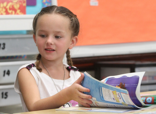 Rick Egan  | The Salt Lake Tribune 

Cienna Parsons thumbs through her book at Polk Elementry School, Wednesday, September 4, 2013. Lawmakers who support Utah's new system for giving letter grades to schools point to Polk Elementary, which received a 'B' grade, as a success story.