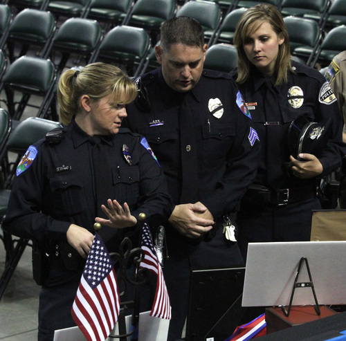 Rick Egan  | The Salt Lake Tribune 

Tanya Turnbow, Todd Hewitt and Alisha Hewitt look at the photos and other memorabilia on display before the funeral for Derek Johnson at the Maverick Center, Friday, September 6, 2013.