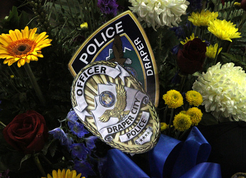 Rick Egan  | The Salt Lake Tribune 

Draper police badges on a bouquet of flowers on display at the funeral for Derek Johnson at the Maverick Center, Friday, September 6, 2013.