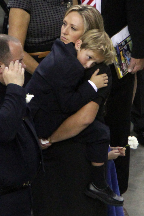 Rick Egan  | The Salt Lake Tribune 

Derek Johnson's wife Shante, holds their son Ben, as the casket is brought into the Maverick Center for the funeral, Friday, September 6, 2013.