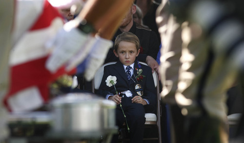 Leah Hogsten | The Salt Lake Tribune
Ben Johnson, 6, watches as Draper police officers fold the flag draping his father Sgt. Derek Johnson's casket. Johnson was laid to rest at Larkin Sunset Mortuary, September 6, 2013. Sgt. Johnson was shot by a transient after the 32-year-old officer pulled up in his patrol car to investigate the manÌs vehicle. The suspect, Timothy Troy Walker, then shot his passenger, Traci Vaillancourt, and himself.