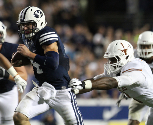 Rick Egan  | The Salt Lake Tribune 

 Brigham Young Cougars quarterback Taysom Hill (4) runs for his third touchdown of the game, as BYU played the University of Texas, Lavell Edwards stadium, Saturday, September 7, 2013.