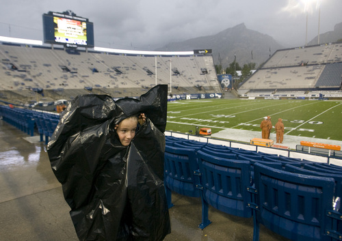 Rick Egan  | The Salt Lake Tribune 

Enoch Frazier, 10, Alpine peeks out of a garbage bag, as the game was delated, and fans were told to seek cover from the rain and lightening, as a huge rainstorm hit Lavell Edwards stadium, an hour before game time, as BYU prepared to face the University of Texas, Saturday, September 7, 2013.