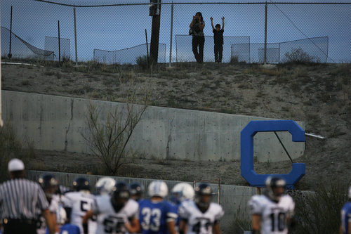 Scott Sommerdorf   |  The Salt Lake Tribune
A pair of fans watches from outside the fence at Carbon HIgh's field in Price. Duchesne High held a commanding 35-0 lead at the half against Carbon High in Price, Friday, September 6, 2013. Duchesne is trying to break the state record for consecutive wins.