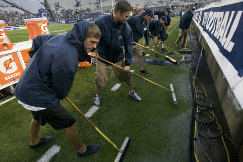 Rick Egan  | The Salt Lake Tribune 

BYU grounds crews squeegee water form the field during the rain delay, as a huge rainstorm hit Lavell Edwards stadium, an hour before game time, as BYU prepared to face the University of Texas, Saturday, September 7, 2013.