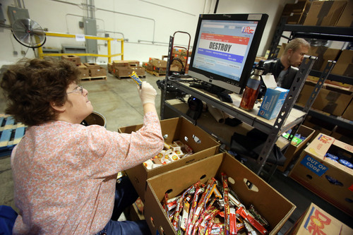 Francisco Kjolseth  |  The Salt Lake Tribune
Kim Snieder, left, and Benjamin jensen of the Columbus Community Center use optical scanners to determine if a product should be donated or destroyed at their facility in West Salt Lake. Smith's has partnered with the local nonprofit that serves people with disabilities, to operate a centralized reclamation center where unsold non-perishable products are scanned, sorted, and prepared to distribute to Utah Food Bank and other statewide food pantries.