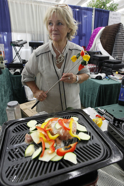 Al Hartmann  |  The Salt Lake Tribune
Paulette Barker prepares a meal of chicken and vegetables on a potrable propane stove she sells at the Utah State Fair. She has sold the portable stoves popular with campers and hunters for several years. She said that her business has been slow this year due to competing festivals this past weekend and rainy weather.