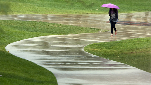 Rick Egan  | The Salt Lake Tribune 

University of Utah Student, Megan Scaglione,Tampa Florida,  makes her way up the sidewalk in the rain, on the U of U campus, Friday, September 13, 2013.