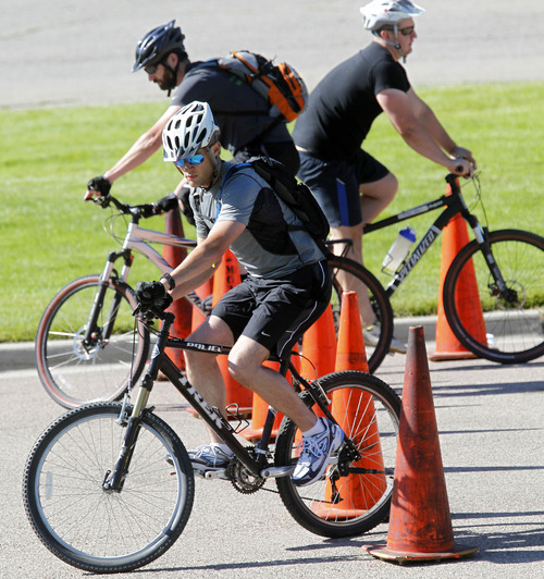 Al Hartmann  |  The Salt Lake Tribune
Police officers weave their bikes through a slalom course of cones in a training excercise to improve their riding skills at a training to become  bike patrol officers. Ten candidates from Salt Lake City police department and four officers from other agencies participated in the training at Sugar House Park in June.