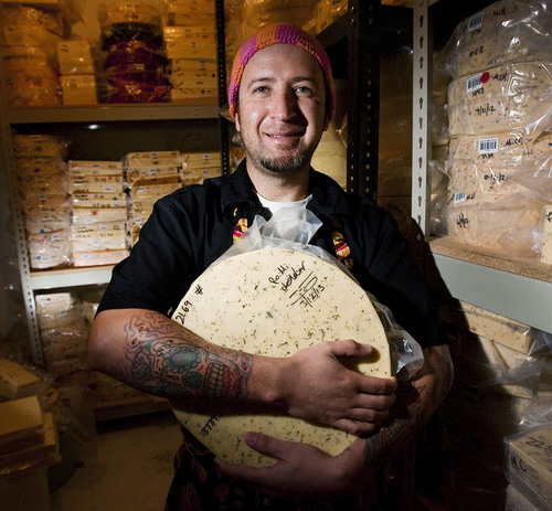 Steve Griffin | The Salt Lake Tribune

Cheese maker Fernando Chavez-Sandoval holds a wheel of rosemary mint cheddar in one of the many coolers at Gold Creek Farm in Woodland, Utah, Monday Sept. 11, 2013.
