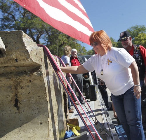 Al Hartmann  |  The Salt Lake Tribune
Gold Star Mother Suzanne Wagstaff, whose son Chief Warrant Officer Matthew G. Wagstaff died in a helicopter crash in Afghanistan, touches a 4 1/2 ton piece of the World Trade Center that went on display at Fort Douglas Military Museum Friday September 20. It will be on display Saturday at Rice-Eccles Stadium and then travel around the state. Eventually, the piece is to be put on permanent display in a planned peace park at Fort Douglas.